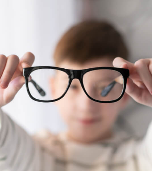 Myopia Management - Boy Holding Eyeglasses